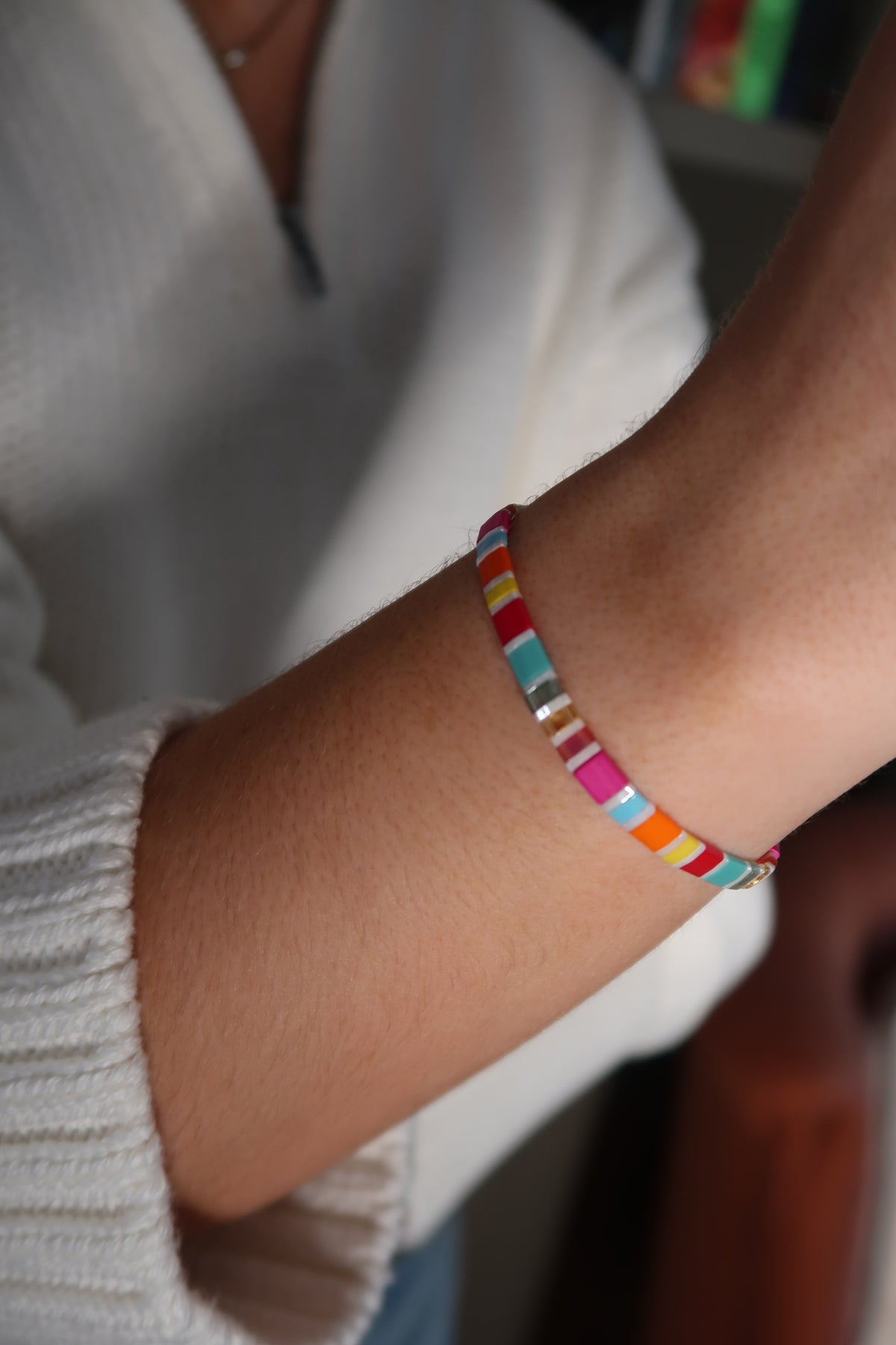 Fantasy Bookshelf Bracelet Second Edition with colorful glass beads and silver-toned accents, worn with a cream knit sweater.