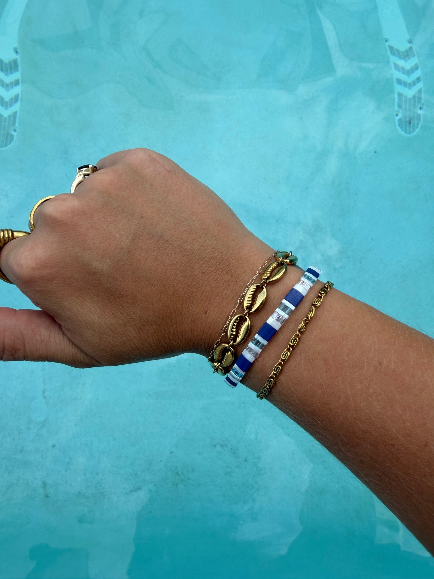 Gold Whirlpool Bracelet stacked with the Whale Shark glass bead bracelet on the wrist.