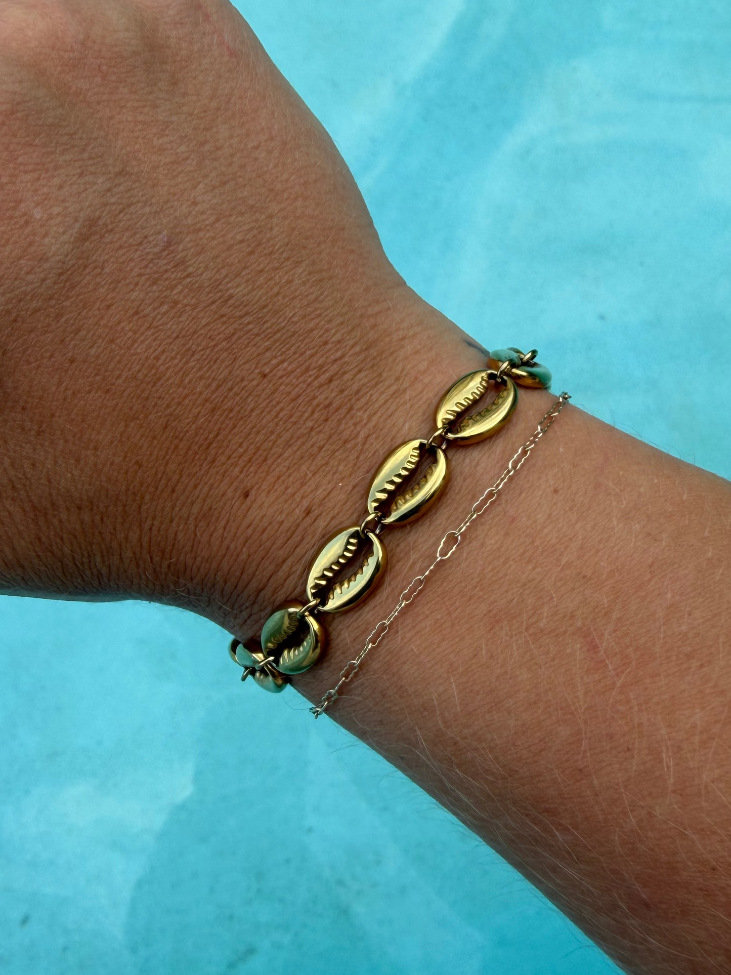 Gold Island Cowrie Bracelet featuring polished cowrie shell links and an adjustable extender chain.