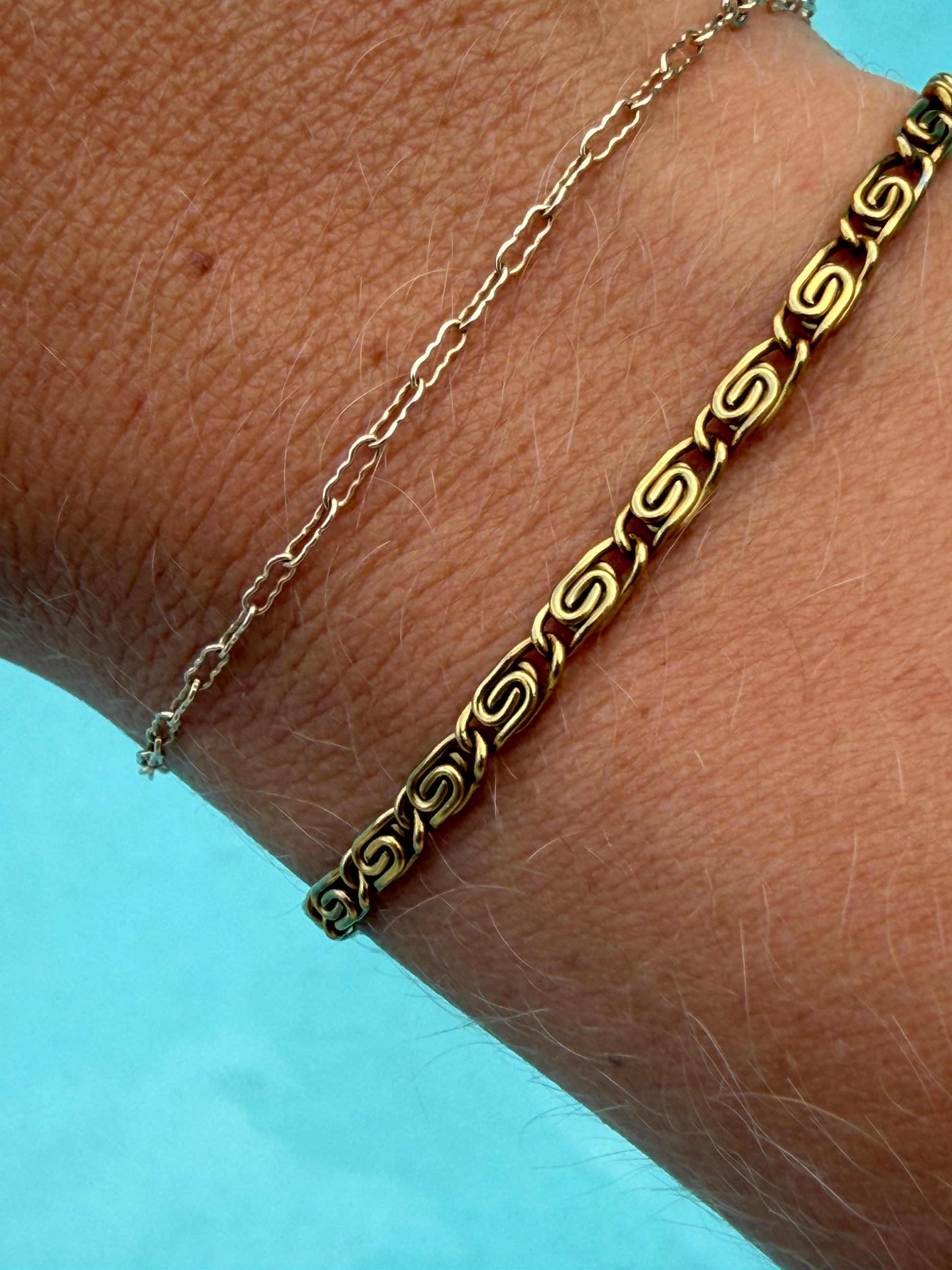Gold Whirlpool Bracelet featuring repeating swirl-shaped links and an adjustable chain.