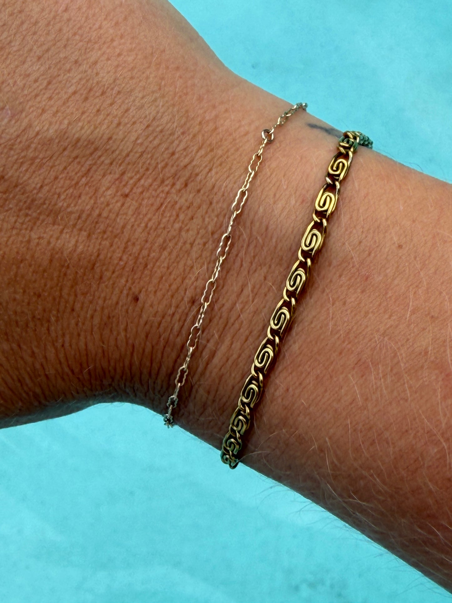Gold Whirlpool Bracelet featuring repeating swirl-shaped links and an adjustable chain.